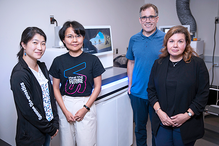 Four researchers stand infront of a clinical RNA sequencer at SickKids.
