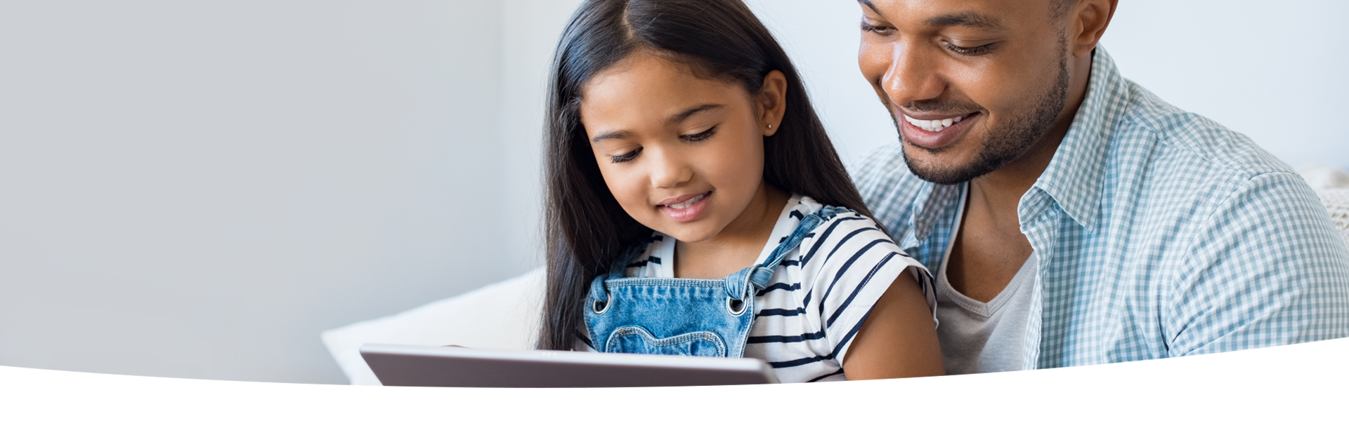 Parent and child look at a tablet together.