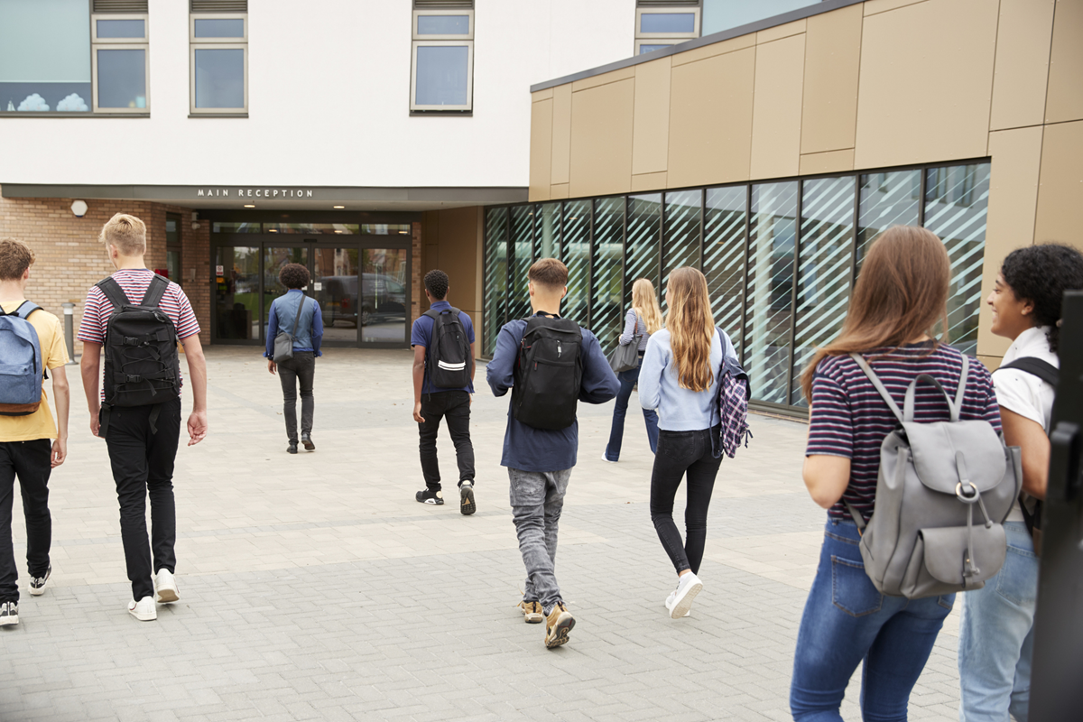 Teens walking toward school doors