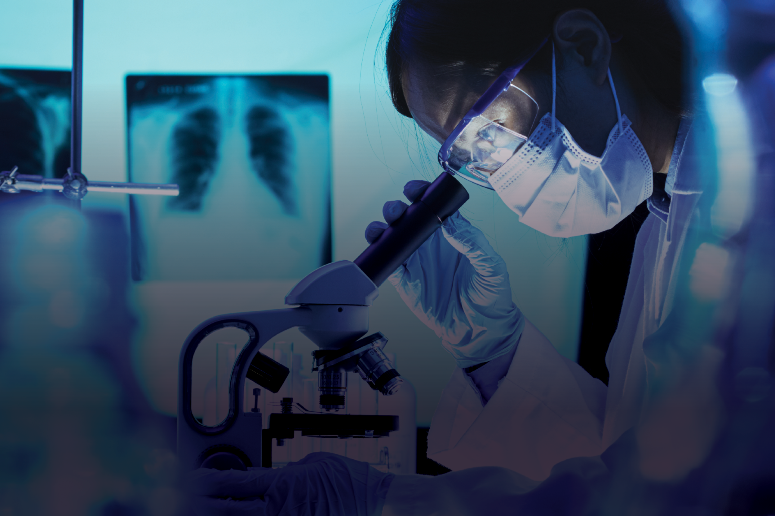 A scientist in a lab coat looks into a microsope.