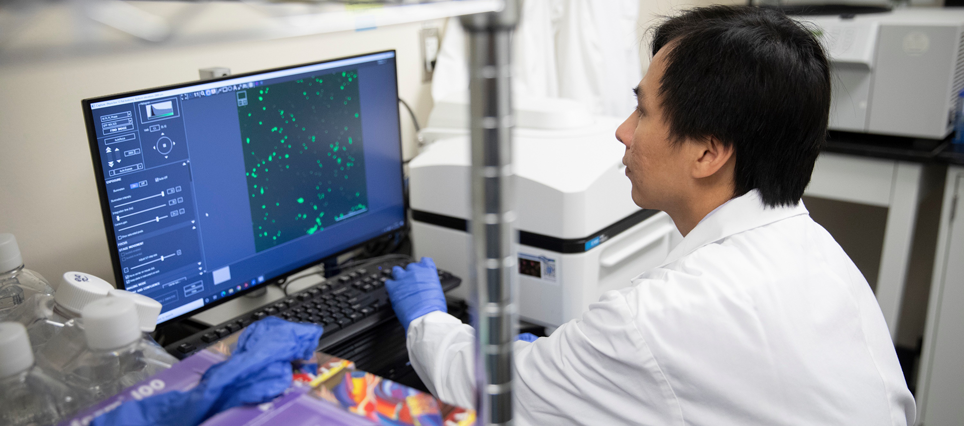 Dr. Toan Nguyen sits at a screen with green dots.