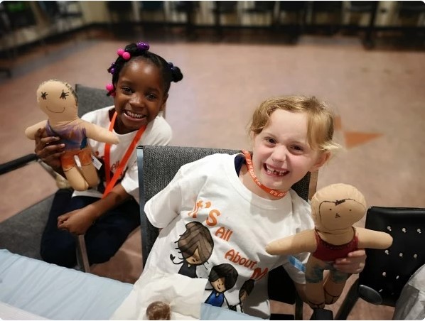 Two kids smiling holding toys