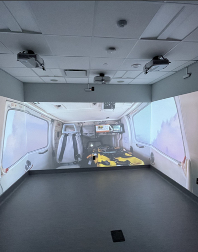 A room with projectors projecting a scene inside an ambulance on the three walls of the room.