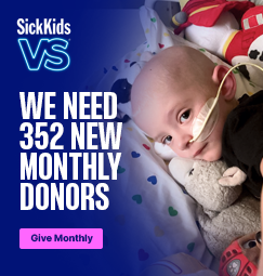 A young child with nasogastric tube inserted, looking at the camera.. SickKids VS. We need 352 new monthly donors. Give monthly.