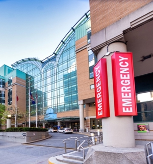 The main entrance at SickKids featuring a large red 'Emergency' sign and a driveway.