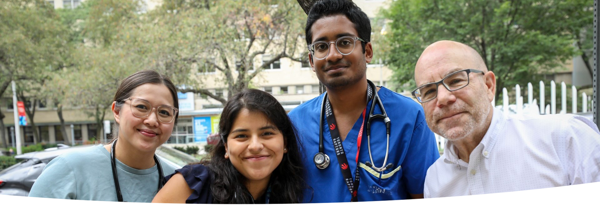 Four staff members together, outside.