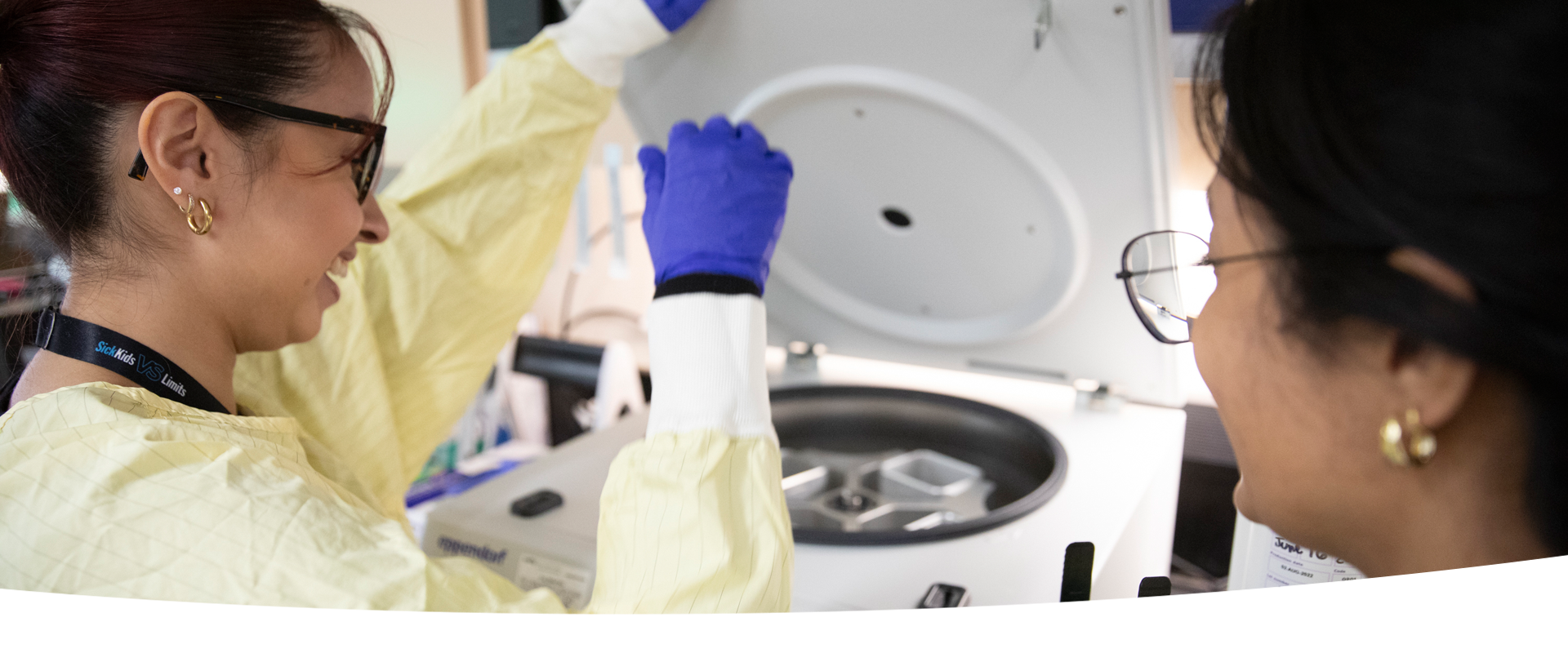 Two people use lab equipment.