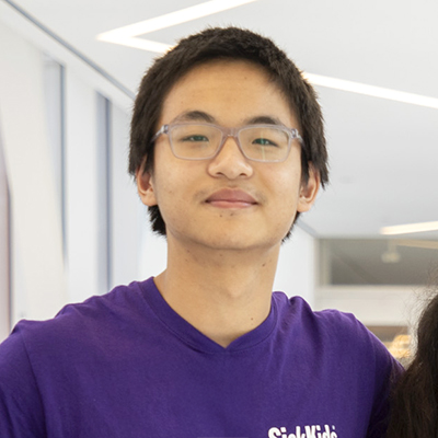 Headshot of young man wearing purple shirt and SickKids lanyard.
