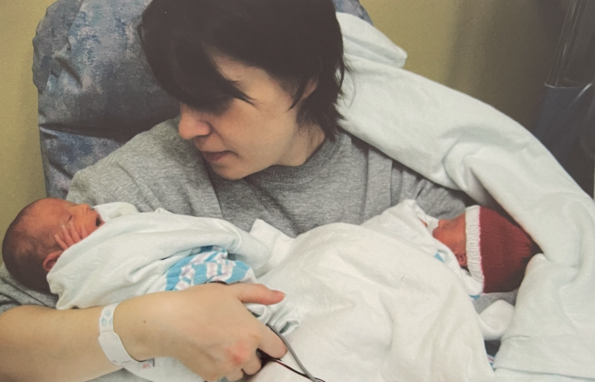 Rita holding newborn John and Sophia.