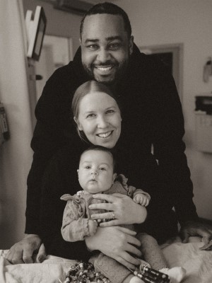 Parents Justin and Stephanie with Sloane in a black and white photo.