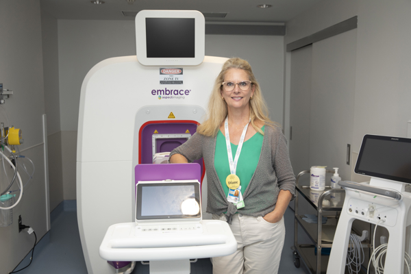 Diane Wilson, NP, stands in front of a neonatal MRI machine.